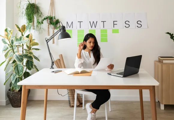 Business owner sitting at a desk, reviewing a financial report on her laptop.