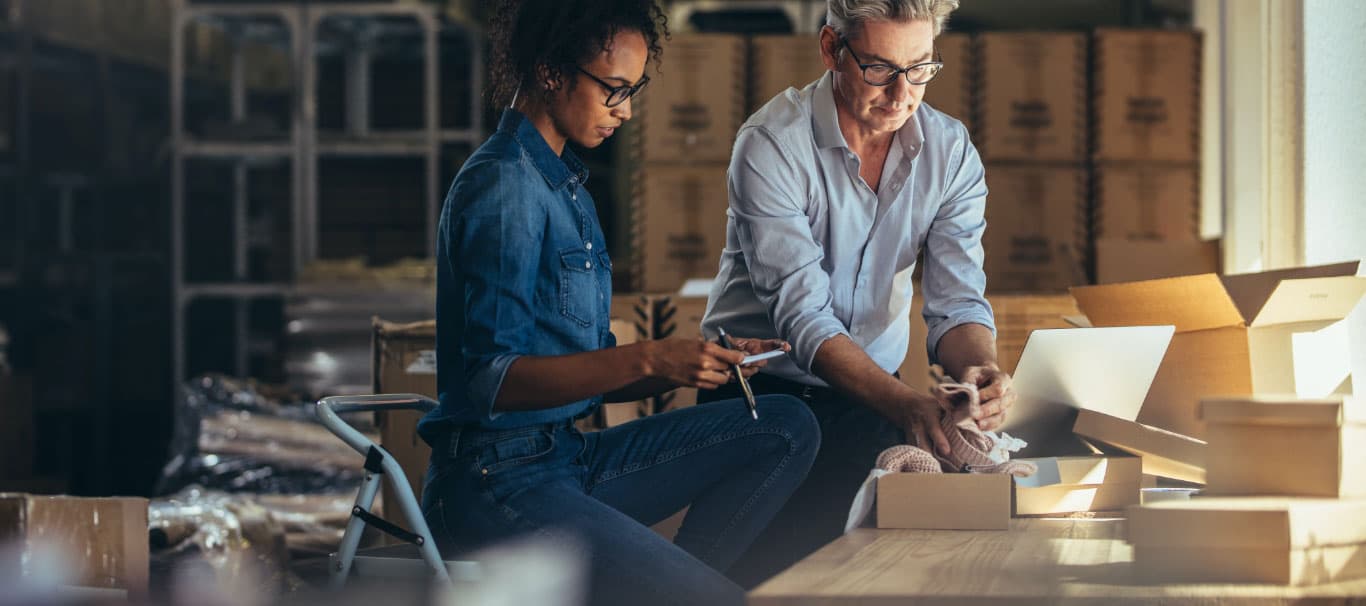 Two people reviewing products in a warehouse.