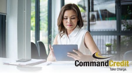 A woman sitting at a desk using a tablet.