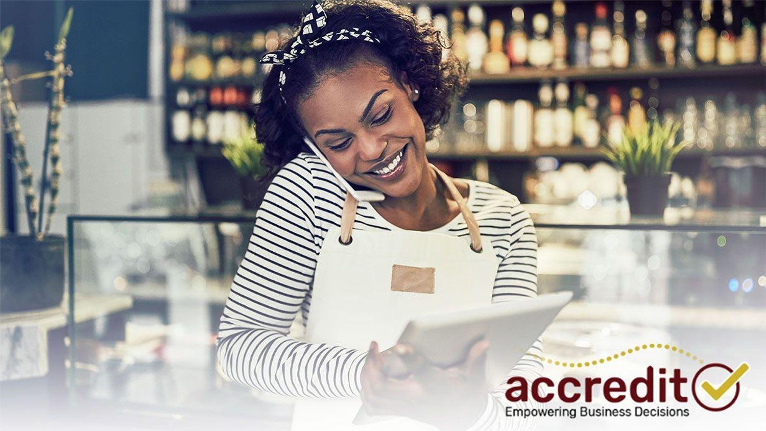Woman talking on a phone while holding a tablet.