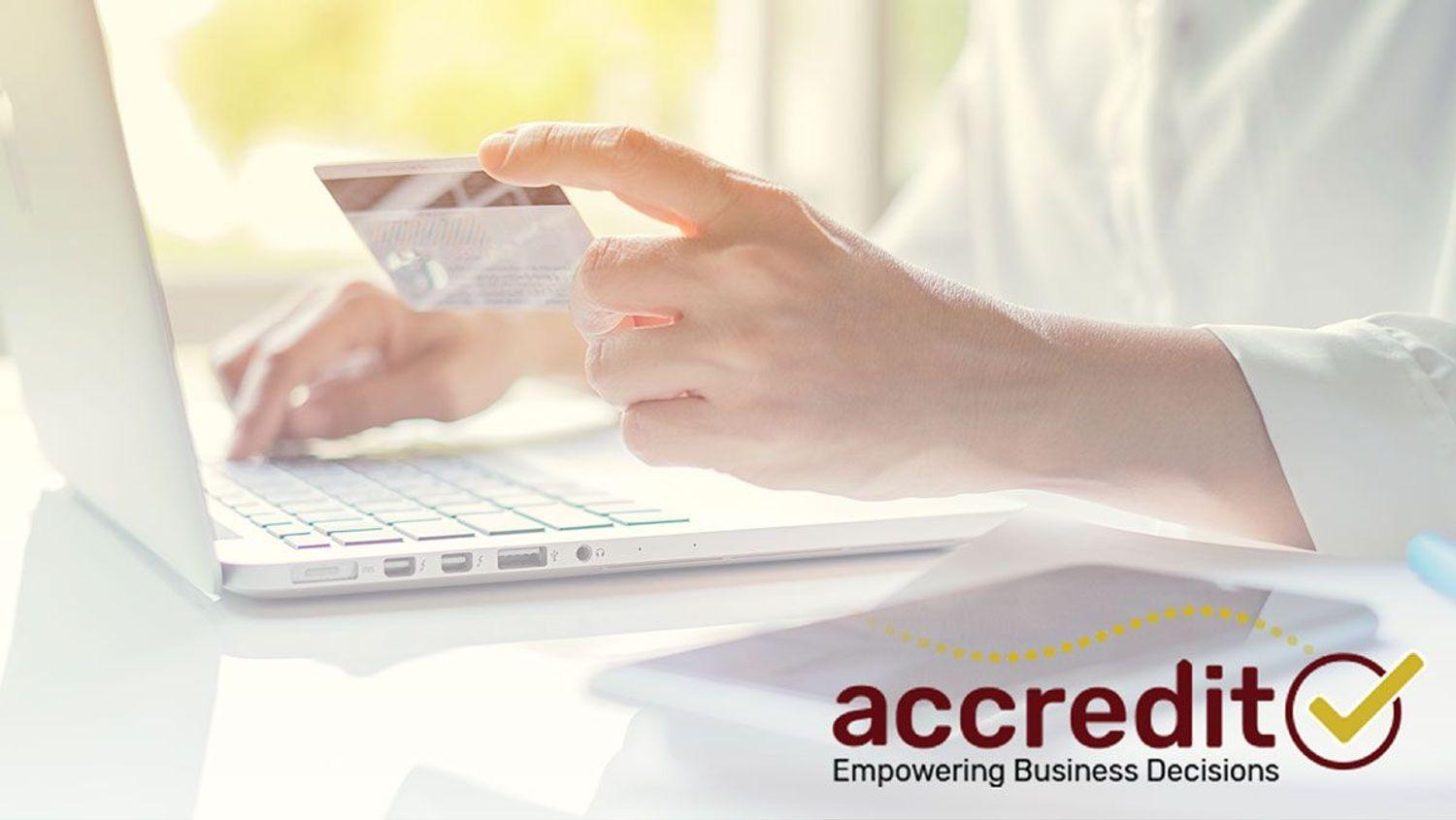 Person typing while holding a card.