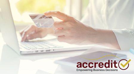 Person typing while holding a card.