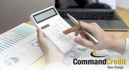 A close up of a person's hands, entering numbers into a calculator. The Command Credit logo is in the bottom right corner.