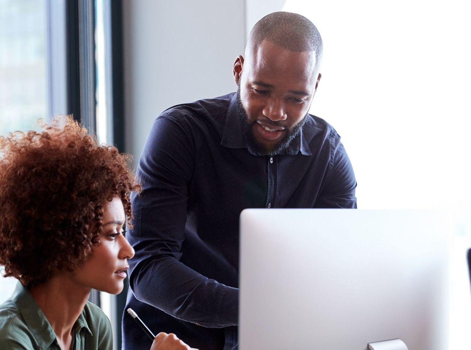 Two people working on a computer.