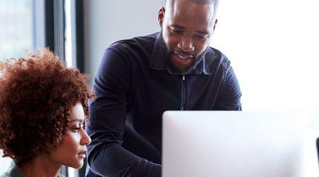 Two people working on a computer.