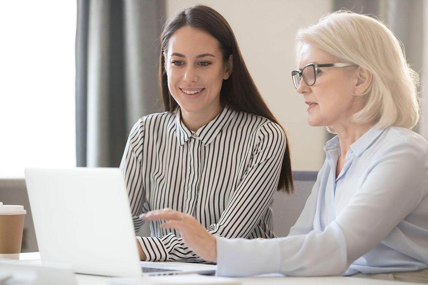Two people working on laptop.