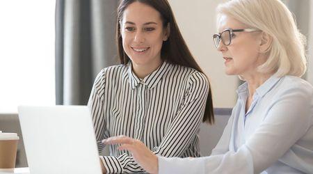 Two people working on laptop.